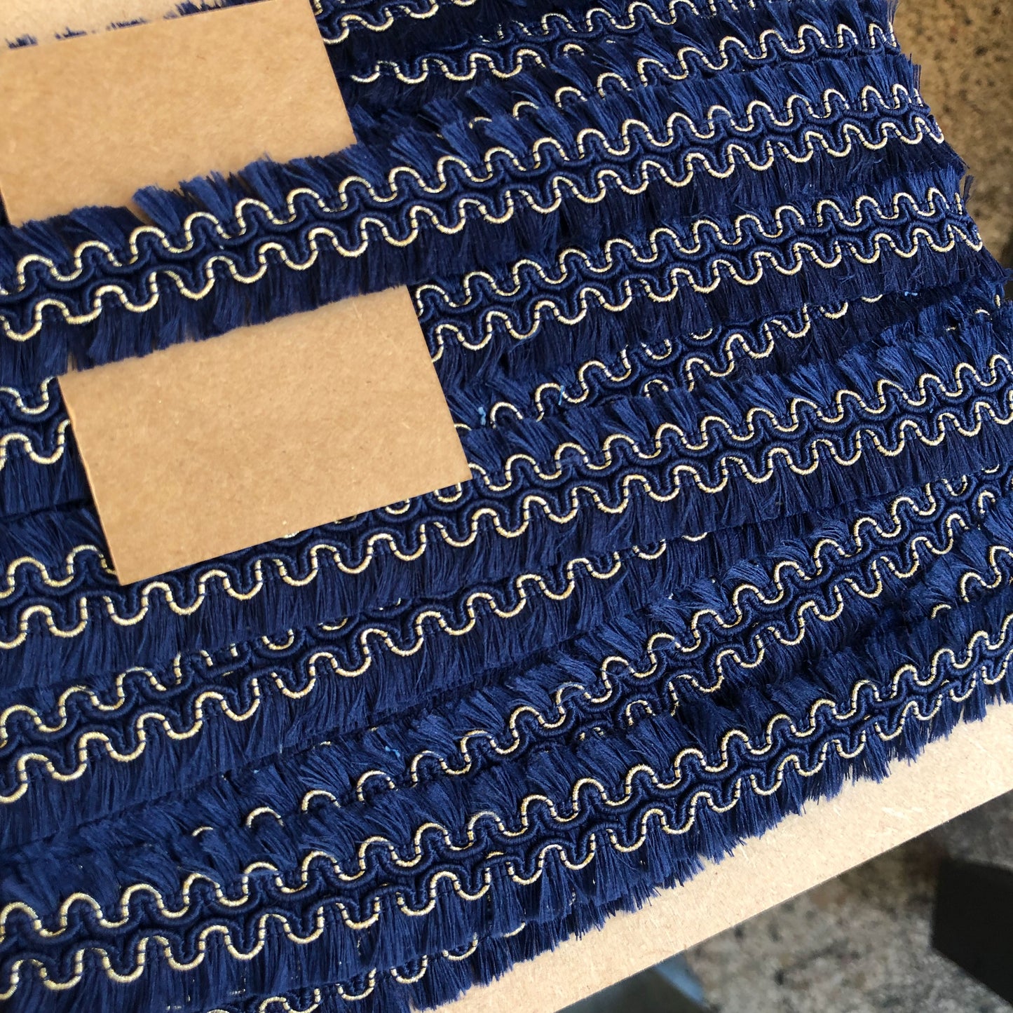 Een sierband met karakter: diepe donkerblauwe franjes gecombineerd met een subtiel goudkleurig detail geven deze band een chique en bohemien uitstraling.