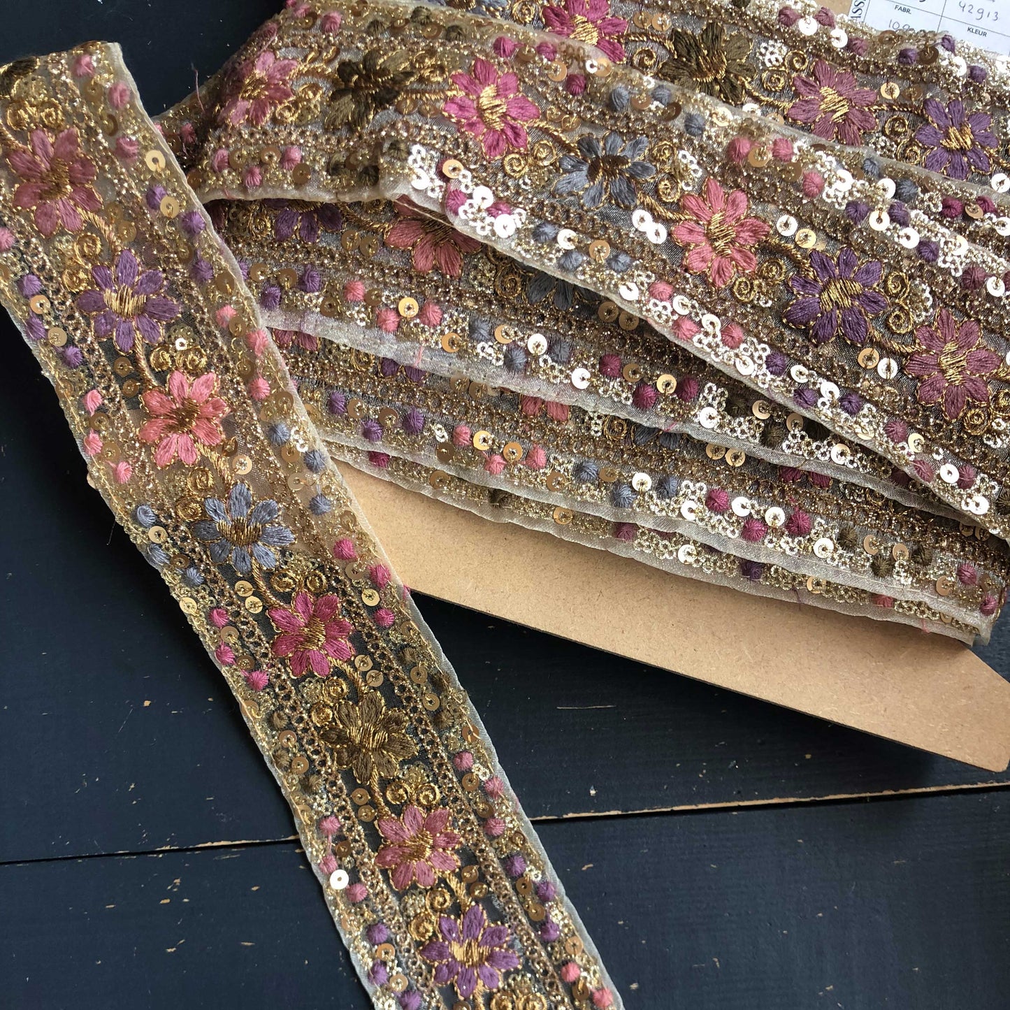 Dit prachtige sierband in lavendeltinten is rijkelijk versierd met geborduurde bloemen en sprankelende pailletten.