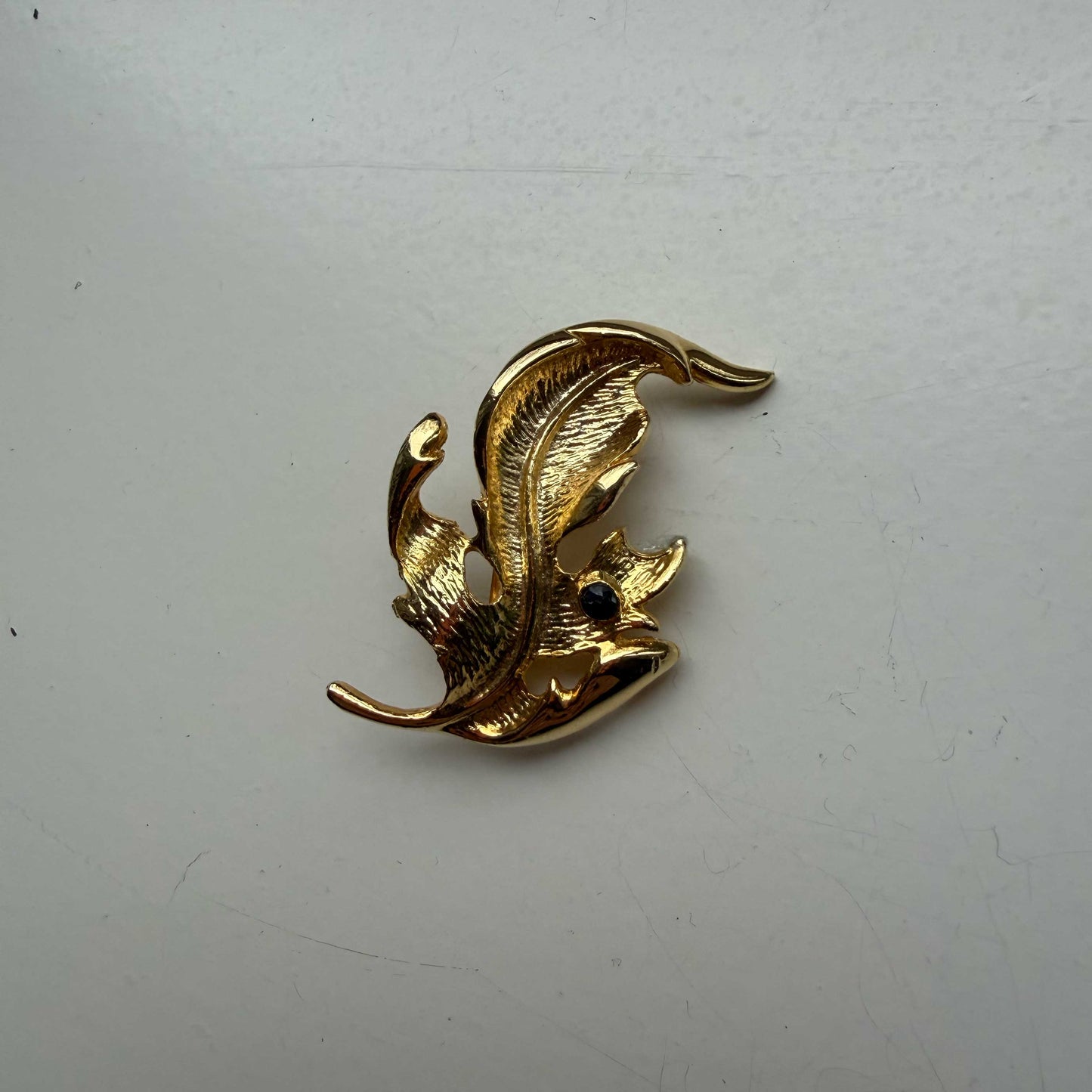 Vintage broche goud in bladvorm met zwart steentje