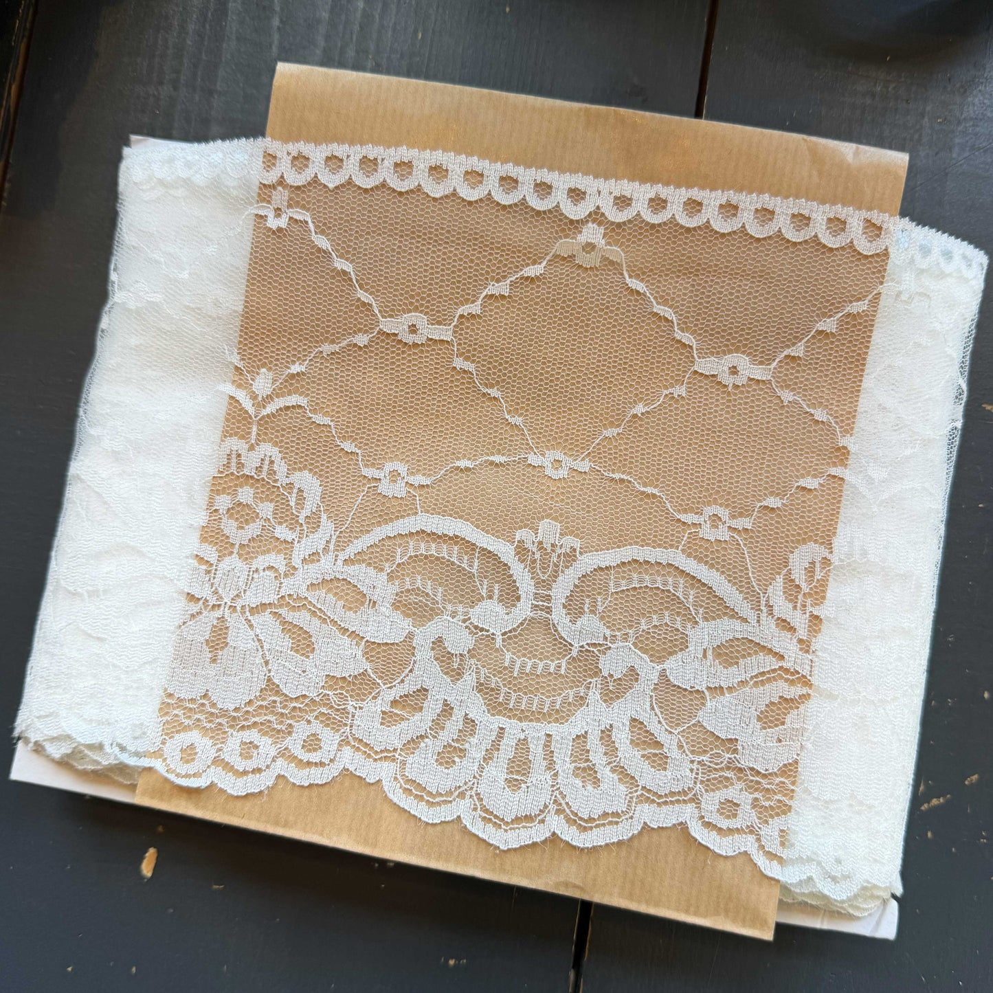 Dit verfijnde witte kant van 15 cm breed heeft een elegante en luchtige uitstraling. Het delicate patroon en de lichte transparantie geven elk ontwerp een zachte, romantische touch.