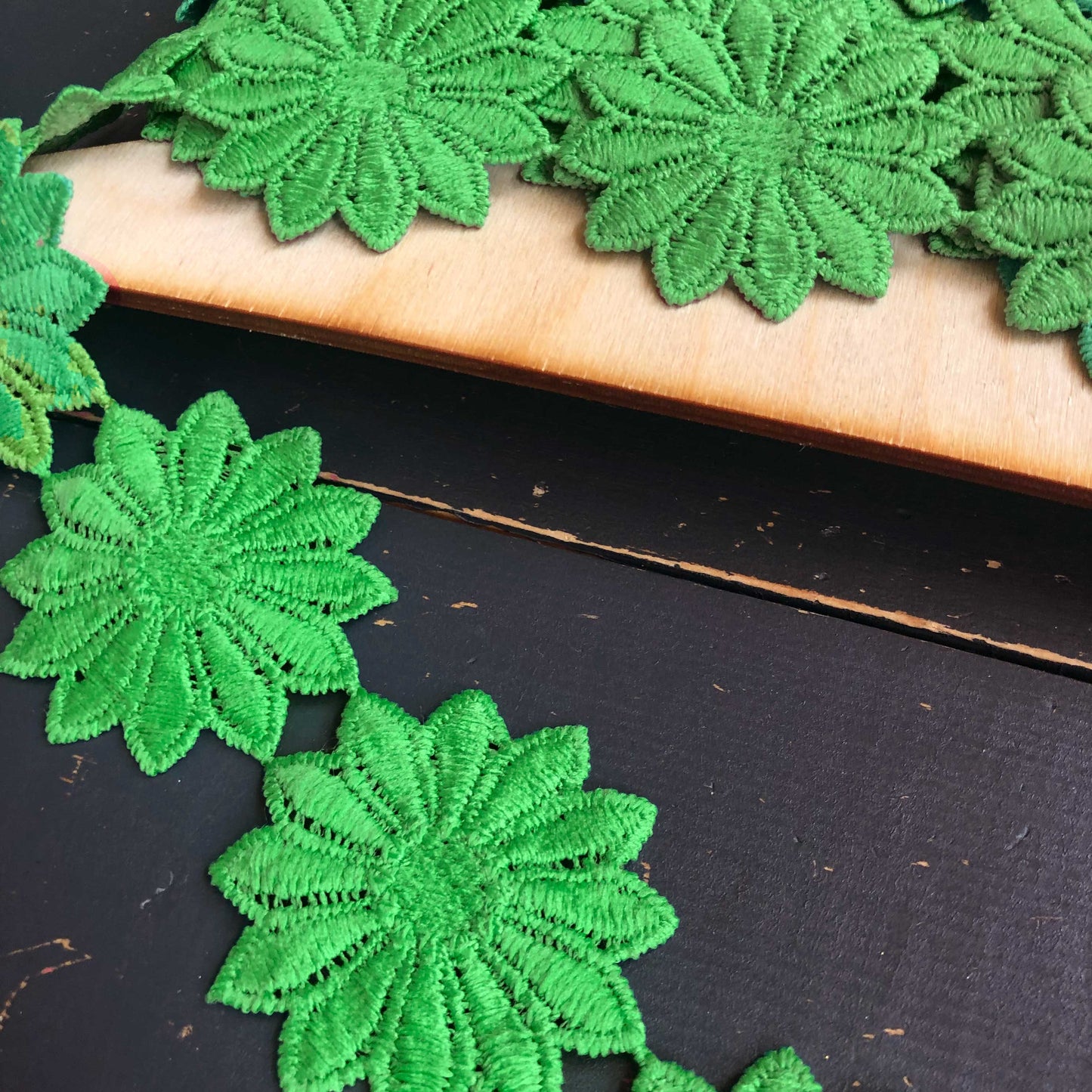 Dit bijzondere sierband is versierd met grote, sierlijke bloemen in een diepe felle groene tint. De bloemen staan los van elkaar waardoor het band meteen in het oog springt. 