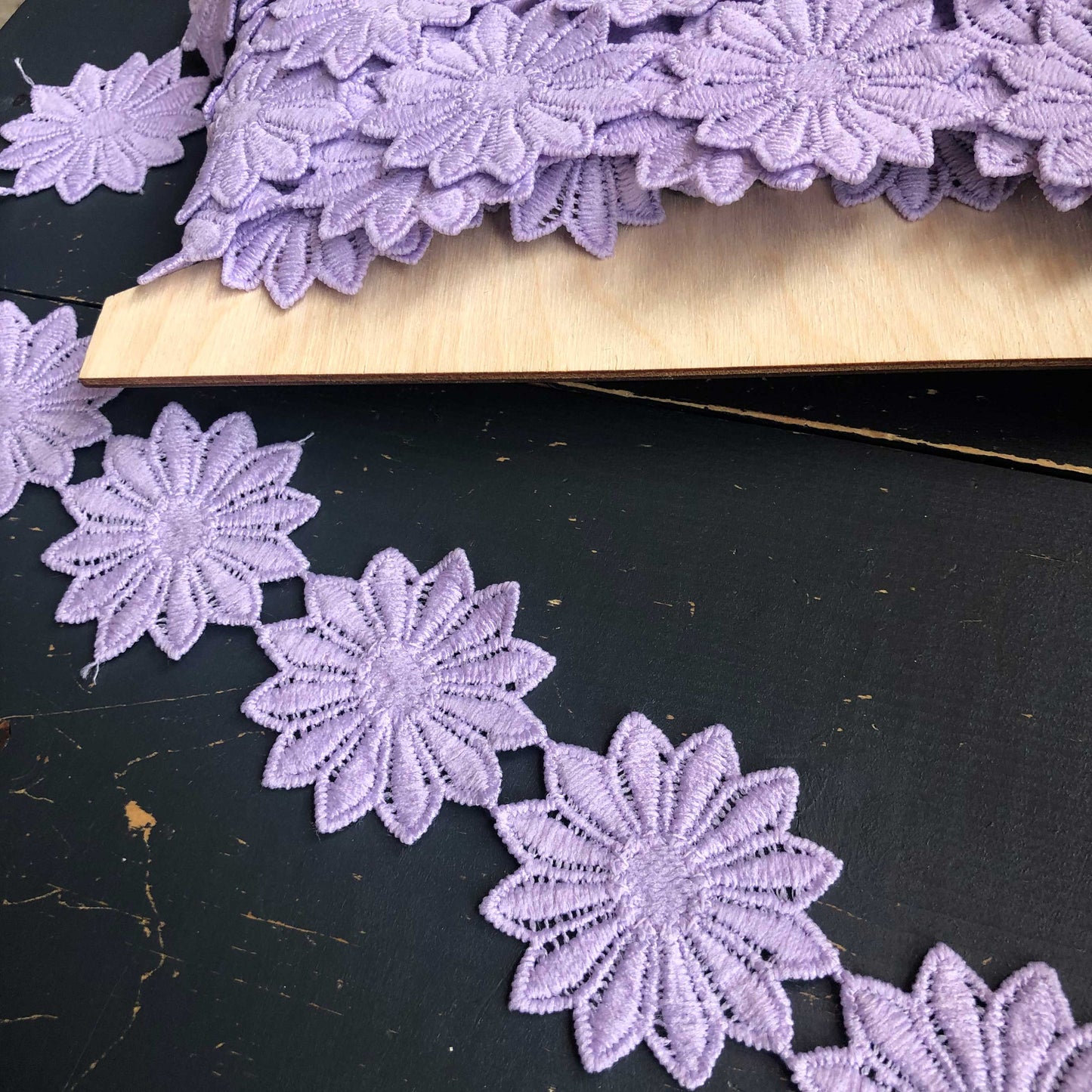 Dit bijzondere sierband is versierd met grote, sierlijke bloemen in een zachte lila tint. De bloemen staan los van elkaar waardoor het band meteen in het oog springt.