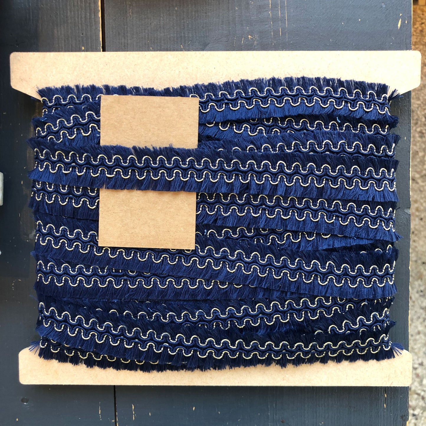 Een sierband met karakter: diepe donkerblauwe franjes gecombineerd met een subtiel goudkleurig detail geven deze band een chique en bohemien uitstraling.