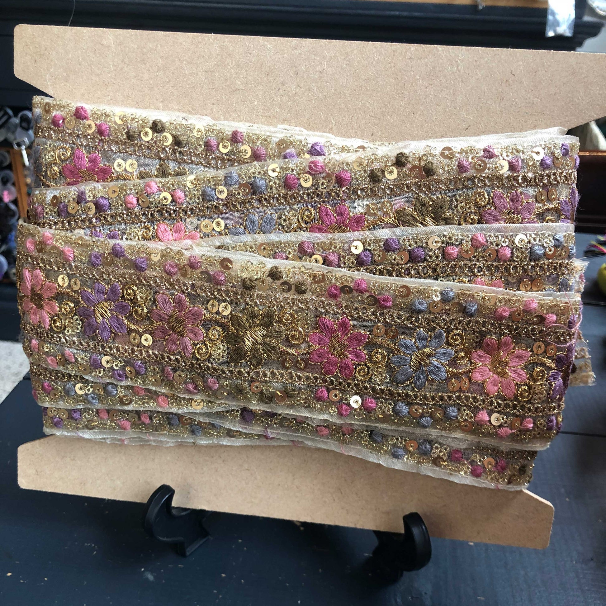 Dit prachtige sierband in lavendeltinten is rijkelijk versierd met geborduurde bloemen en sprankelende pailletten. 