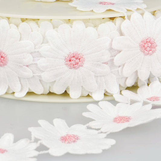 Breng een vleugje vrolijkheid in je creaties met deze charmante sierband vol witte madeliefjes. Elke bloem is fijn afgewerkt met een zachtroze hartje, wat zorgt voor een speels en lief effect.