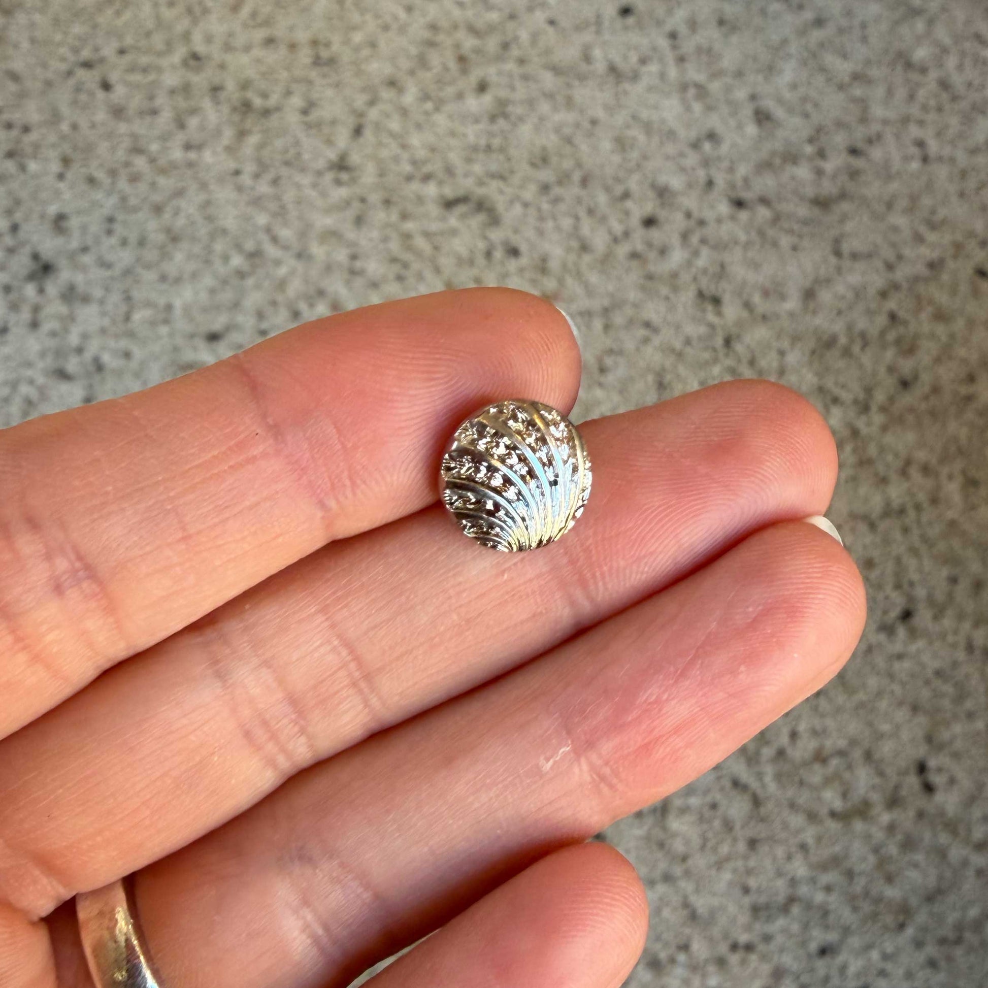 Deze elegante knoop van 11 mm heeft een verfijnd schelpmotief met een subtiel reliëf, 