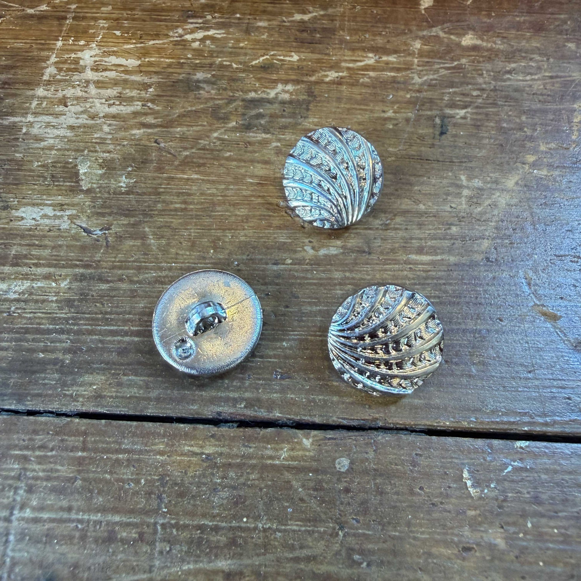 Deze elegante knoop van 15 mm heeft een verfijnd schelpmotief met een subtiel reliëf, 