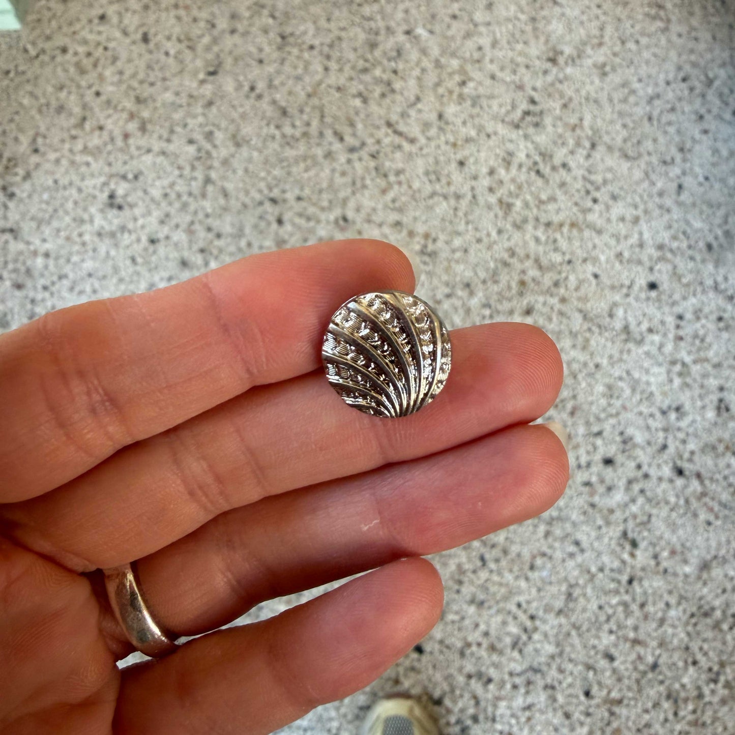 Deze elegante knoop van 15 mm heeft een verfijnd schelpmotief met een subtiel reliëf, 